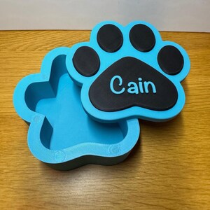 Small paw print keepsake box with a removable magnetic lid, designed for pet ashes or mementos. Holds approx. 170ml, ideal for small pets like cats, rabbits, or toy breed dogs. Custom name engraving included. Thoughtful pet loss gift for remembrance.
