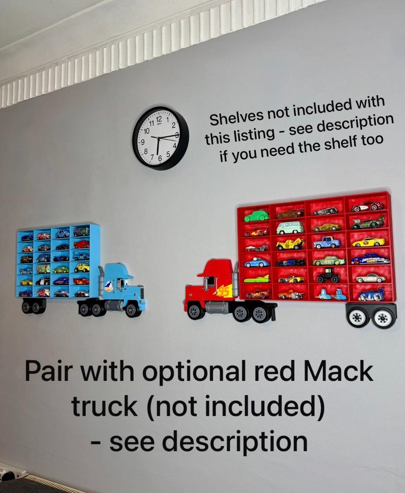 May include: Two toy truck-shaped display shelves mounted on a gray wall. One is blue, the other red, each holding miniature toy cars. A black clock hangs above the shelves. Text on the wall reads, "Shelves not included..." and "Pair with optional red Mack truck..."