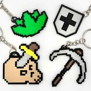 3D printed Old School RuneScape skill icon keychains featuring pixelated designs. Includes iconic skills like Mining, Herblore, defense and slayer. Perfect for RuneScape fans to show off their love for the game as stylish and durable accessories.