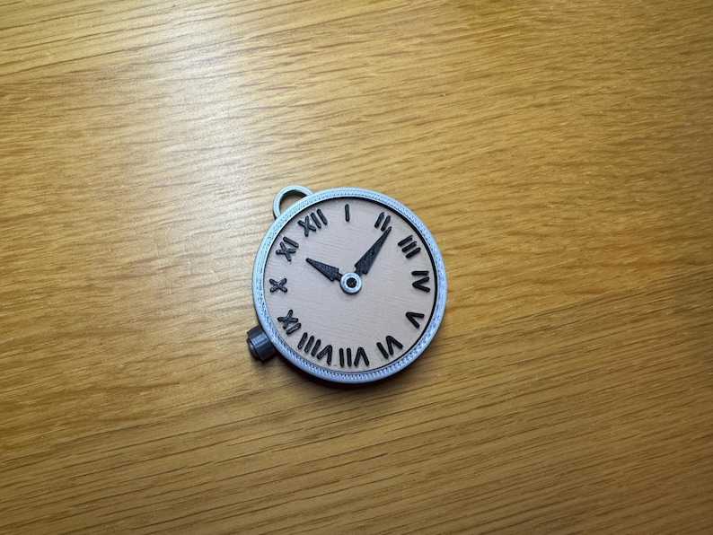 May include: A silver-coloured pocket watch with Roman numeral markings on the face. The watch face is beige with black hands and a black centre.