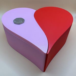 A large 3D-printed heart-shaped box in vibrant red and pastel purple with a sleek split design. Perfect for storing keepsakes, gifts, or jewellery, this eco-friendly PLA box is both functional and decorative, making it ideal for Valentine’s Day.
