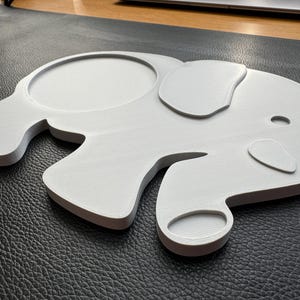 Angled view of the elephant-shaped coaster, highlighting its detailed design and smooth finish.