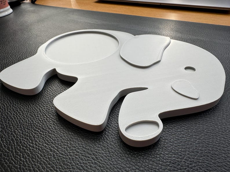 Angled view of the elephant-shaped coaster, highlighting its detailed design and smooth finish.