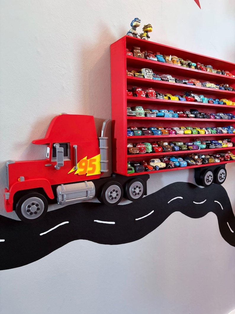 May include: A red wall-mounted display shelf shaped like a semi-truck with a trailer featuring multiple horizontal rows. The truck cab displays the number 95 in yellow. The trailer holds numerous small toy cars arranged on several shelves.