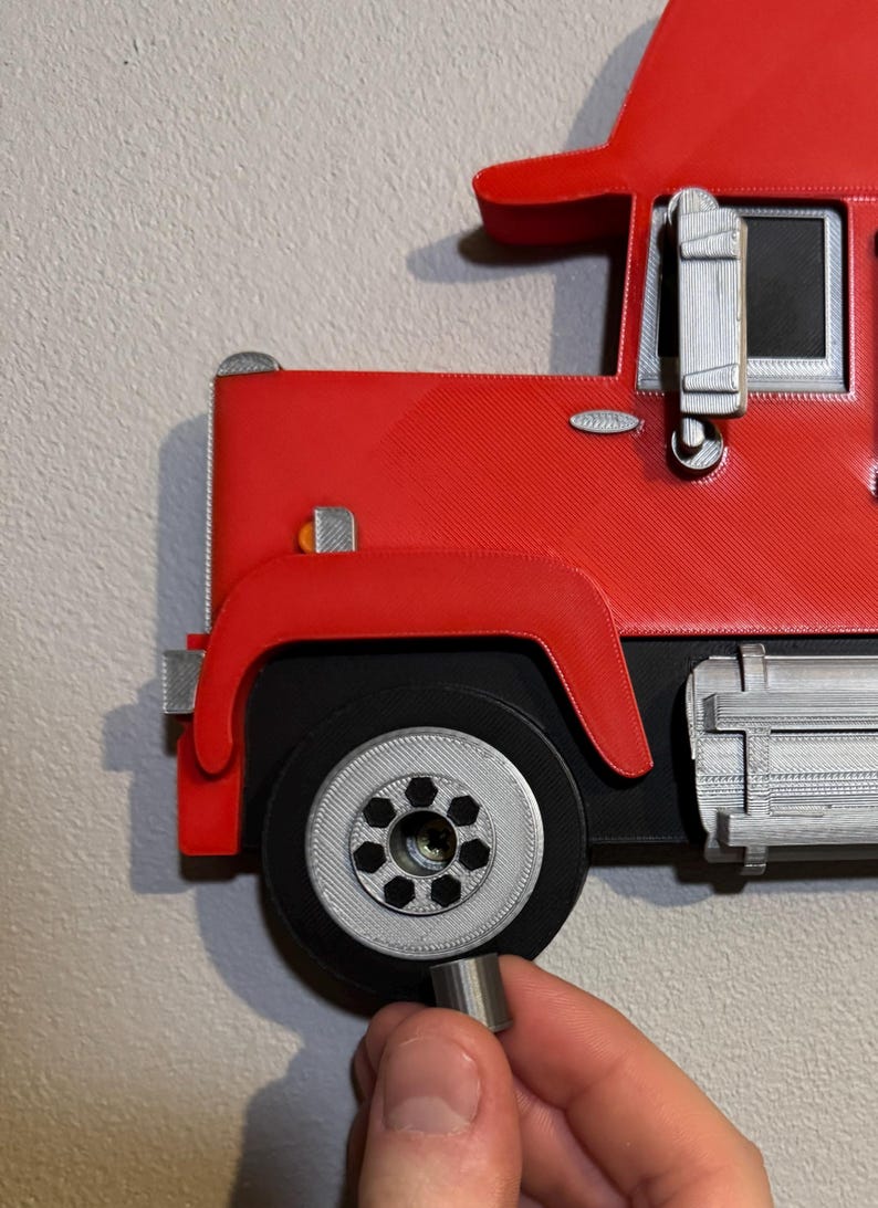 Close-up of Mack truck toy shelf showing a screw cap cover for seamless wall mounting. Practical and stylish, it hides screws for a polished look. Perfect for displaying Hot Wheels or Matchbox cars. Available in red, black, blue, or white.