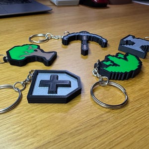 3D printed Old School RuneScape skill icon keychains featuring vibrant, pixelated designs. Includes iconic skills like Mining, Herblore, and defense. Perfect for RuneScape fans to use as charms, keyrings, bag charms or cake toppers.