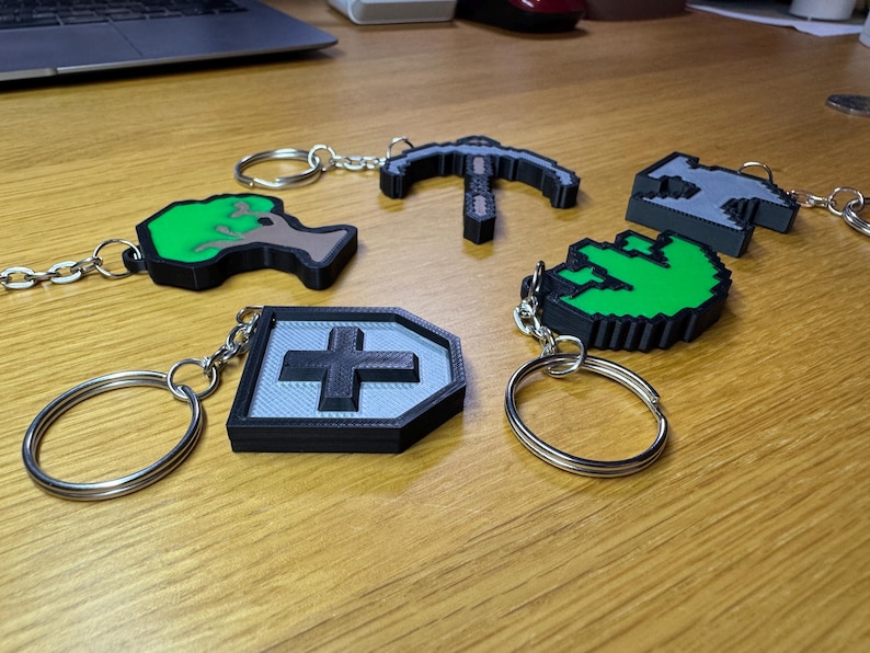 3D printed Old School RuneScape skill icon keychains featuring vibrant, pixelated designs. Includes iconic skills like Mining, Herblore, and defense. Perfect for RuneScape fans to use as charms, keyrings, bag charms or cake toppers.