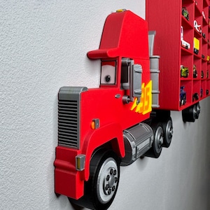 May include: A vibrant red toy truck with a matching trailer, mounted on a wall. The truck features a detailed design with gray accents, including the wheels and engine components. The trailer has multiple compartments, likely for displaying small toy cars.