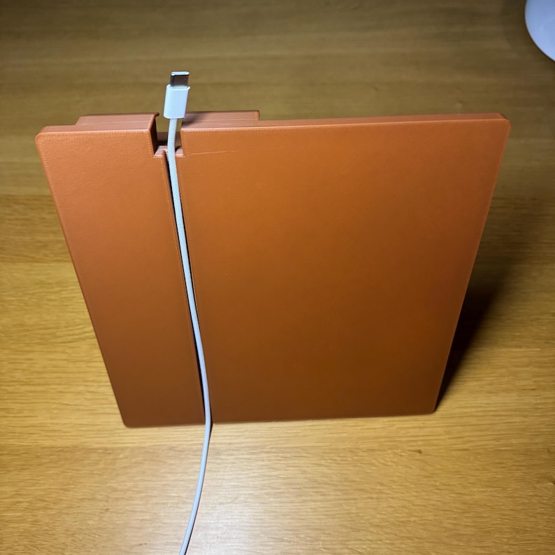 Wood-effect 3D-printed organiser with a built-in cable slot for discreet phone charging. Designed to keep your bedside or desk tidy while allowing easy access to your device.