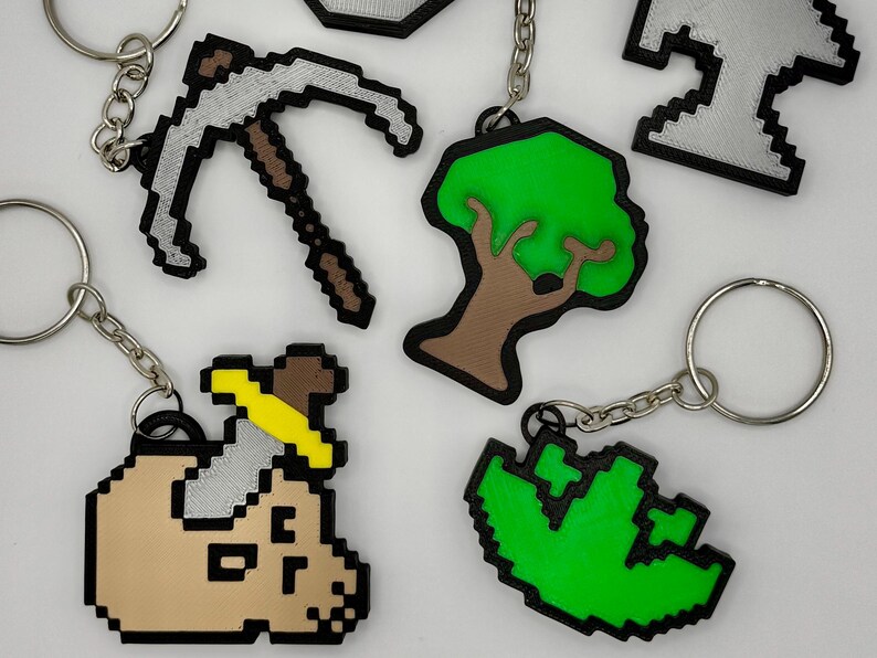 3D printed Old School RuneScape skill icon keychains featuring pixelated designs. Includes skills Mining, Herblore, defense, slayer, woodcutting and smithing. Perfect for RuneScape fans to show off their love for the game with durable accessories.