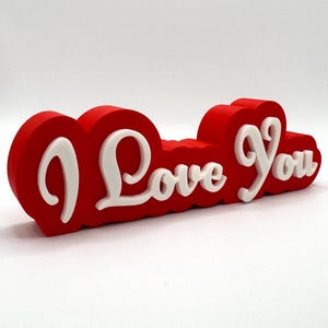 3D printed ‘I Love You’ sign with bold red and white 3D letters. A perfect Valentine’s Day gift, romantic decor, or anniversary present. Unique, high-quality design makes it ideal for bedroom decor, couples’ gifts, or special celebrations of love.
