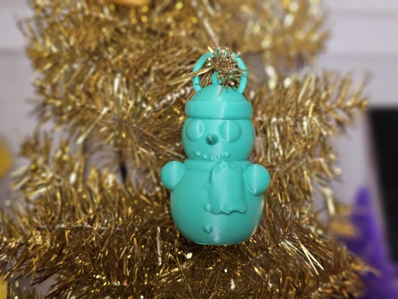3D-printed snowman ornament made from PLA, available in vibrant colours with a built-in loop for hanging. Perfect for decorating Christmas trees, wreaths, or as festive gifts. Lightweight and durable, adding a handmade charm to holiday décor.