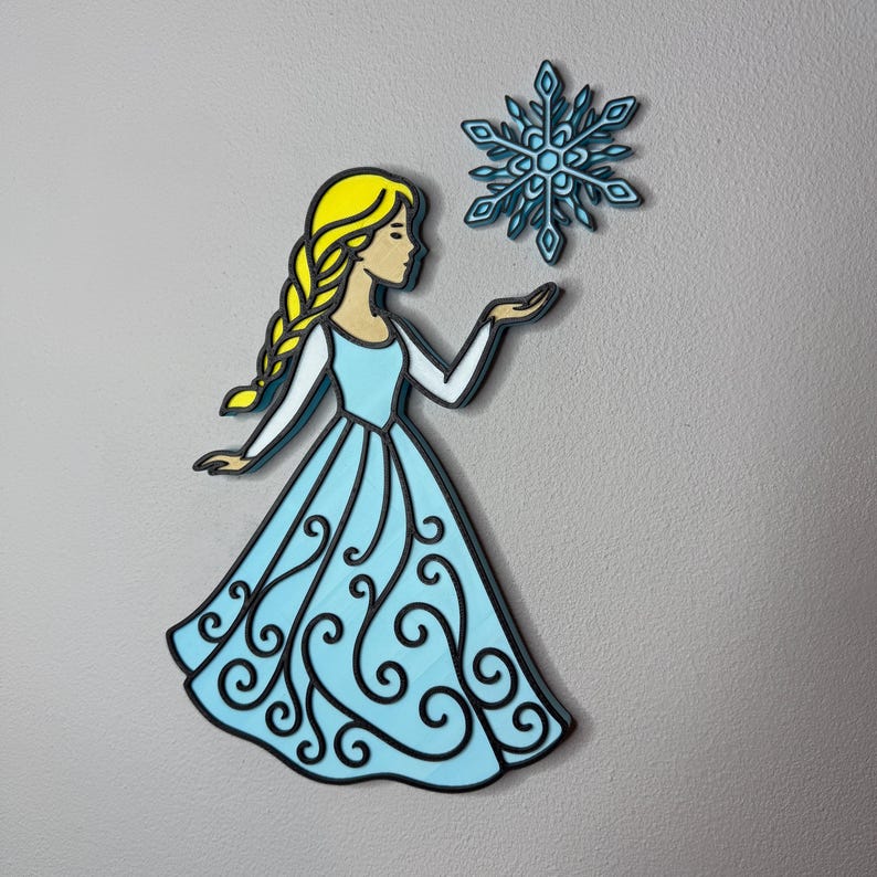 May include: A wooden cutout of a cartoon character in a light blue dress with a yellow braid, holding a blue snowflake. The character has a black outline and is set against a gray background.