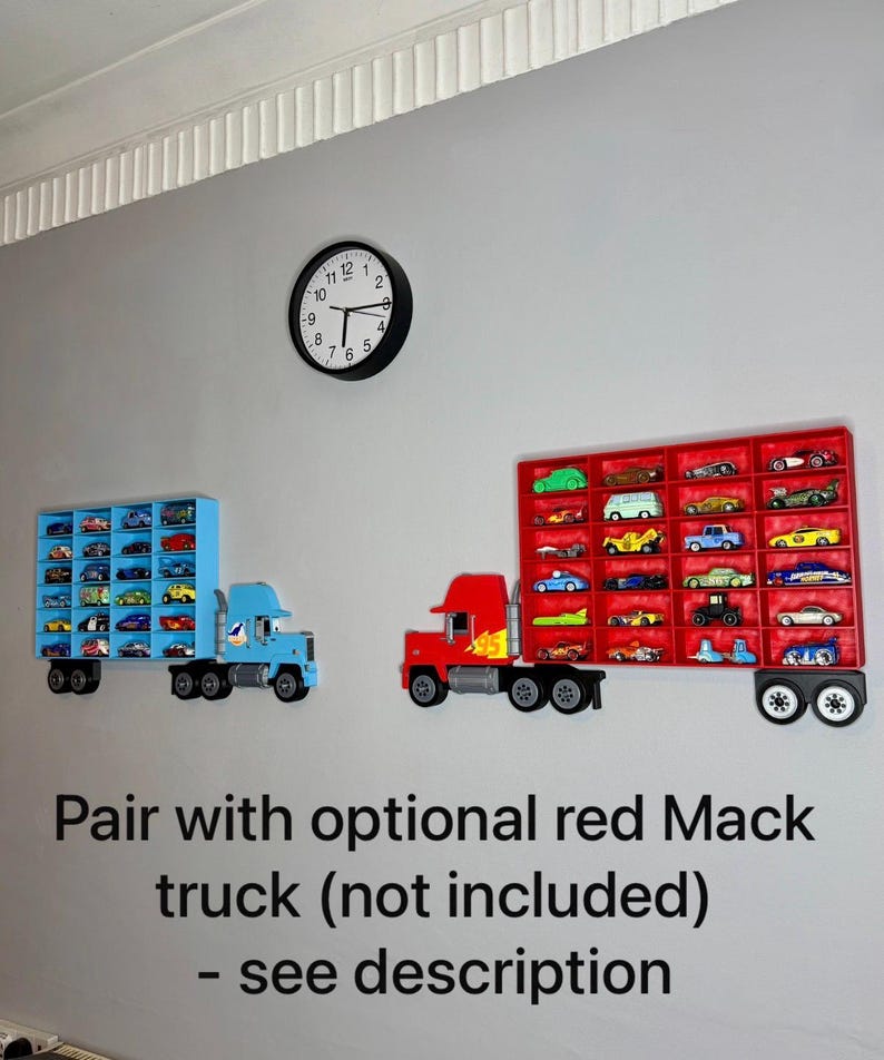 May include: Two toy truck-shaped display shelves mounted on a gray wall, one blue and one red, each filled with miniature toy cars. A black clock hangs above. The text on the wall reads "Pair with optional red Mack truck (not included) - see description."