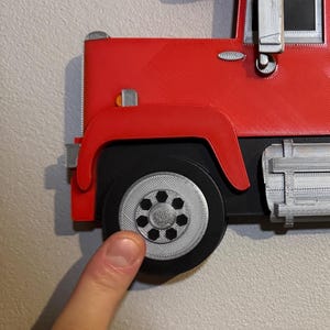 Close-up of Mack truck toy shelf showing a screw cap cover for seamless wall mounting. Practical and stylish, it hides screws for a polished look. Perfect for displaying Hot Wheels or Matchbox cars. Available in red, black, blue, or white.