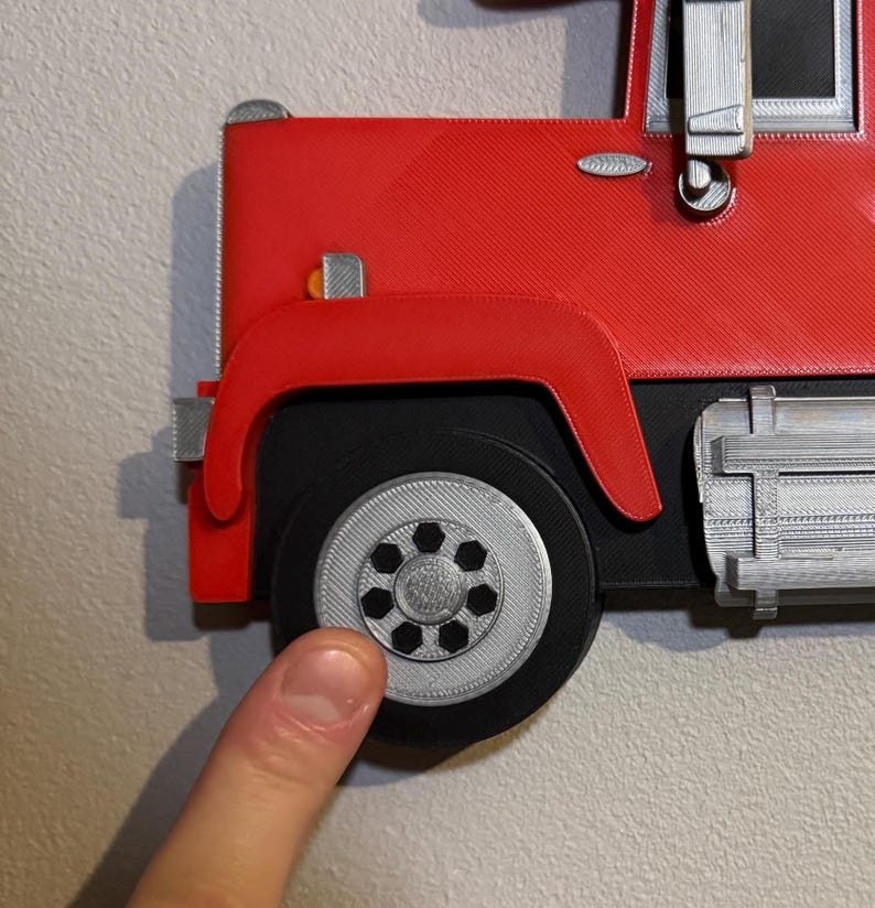Close-up of Mack truck toy shelf showing a screw cap cover for seamless wall mounting. Practical and stylish, it hides screws for a polished look. Perfect for displaying Hot Wheels or Matchbox cars. Available in red, black, blue, or white.
