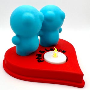 Personalised 3D printed tealight holder featuring cute bubble people figurines on a heart-shaped base. Customisable with names, perfect as a romantic Valentine’s gift, anniversary present, or home decor. Designed for use with LED tealights.