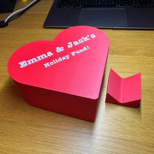 Love heart-shaped piggy bank, ideal for saving coins, Valentine’s Day gifts, or romantic decor. A unique 3D-printed coin bank for kids or couples, perfect as a gift, decorative piece, or practical savings tool.