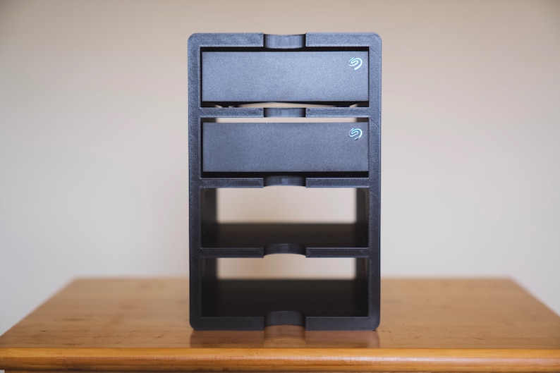 3D printed PLA shelf unit for storing the seagate 8TB Expansion Hard Drive to keep your office or desk tidy and organised. Photo of product with 2 hard drives in, on a desk in an office setting