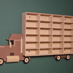 3D-printed truck-themed wall shelf with wooden finish PLA, designed for car storage. Ideal for adult and child car collectors to organise and display collectables neatly in 24 compartments. A functional decor piece that adds charm to any room.