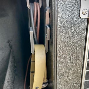 A 3D-printed organiser securely mounted inside a dog crate, designed to hold leads and accessories neatly. A beige leather collar and multiple leads are stored within the hooks, keeping them tangle-free.