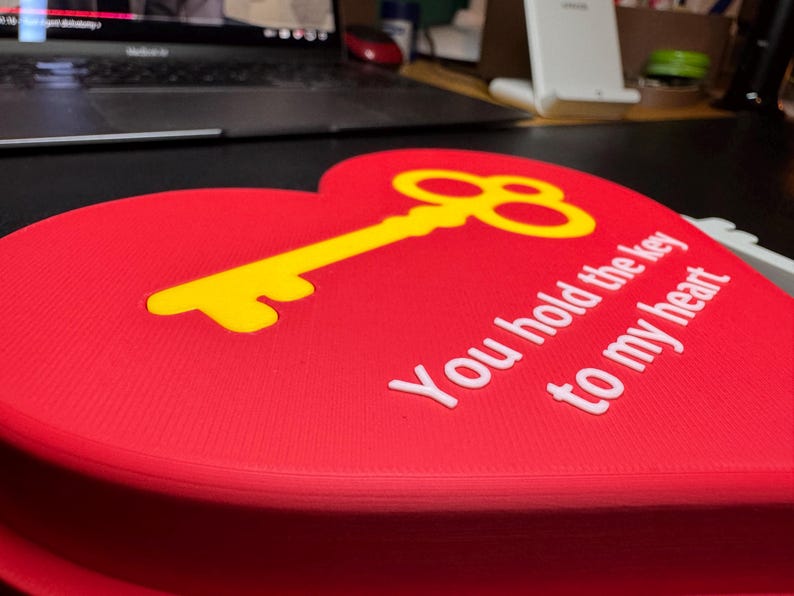 A red heart-shaped 3D-printed decoration with a gold key inset and the text ‘You hold the key to my heart.’ Perfect for a romantic Christmas gift or a creative proposal idea.