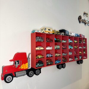 May include: A red truck-shaped shelf unit with multiple compartments, filled with various toy cars. The truck features the number "95" and a lightning bolt graphic. The shelf is mounted on a white wall, creating a playful display for toy car collections.