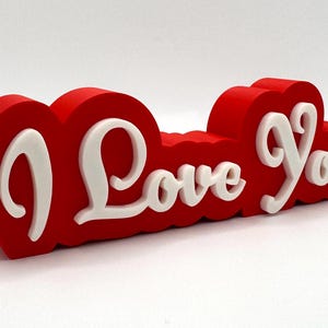 3D printed ‘I Love You’ sign with bold red and white 3D letters. A perfect Valentine’s Day gift, romantic decor, or anniversary present. Unique, high-quality design makes it ideal for bedroom decor, couples’ gifts, or special celebrations of love.