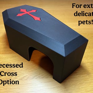 A black 3D-printed gothic reptile hide with a recessed red cross on top. Text overlay highlights the flush design, making it safer for delicate pets. Ideal for snakes, geckos, and other small reptiles.