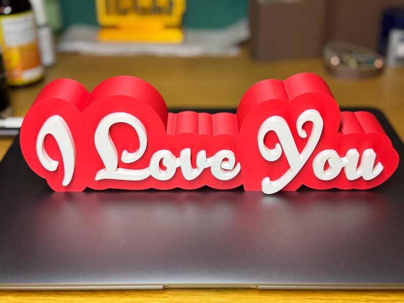 3D printed ‘I Love You’ sign with bold red and white 3D letters. A perfect Valentine’s Day gift, romantic decor, or anniversary present. Unique, high-quality design makes it ideal for bedroom decor, couples’ gifts, or special celebrations of love.
