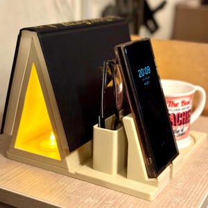 bedside storage organiser with book rest, phone stand, and pen holder. Versatile design with a built-in LED tea light slot for soft lighting. Perfect for keeping nightstand essentials neat and accessible. 3D printed, durable, and lightweight.