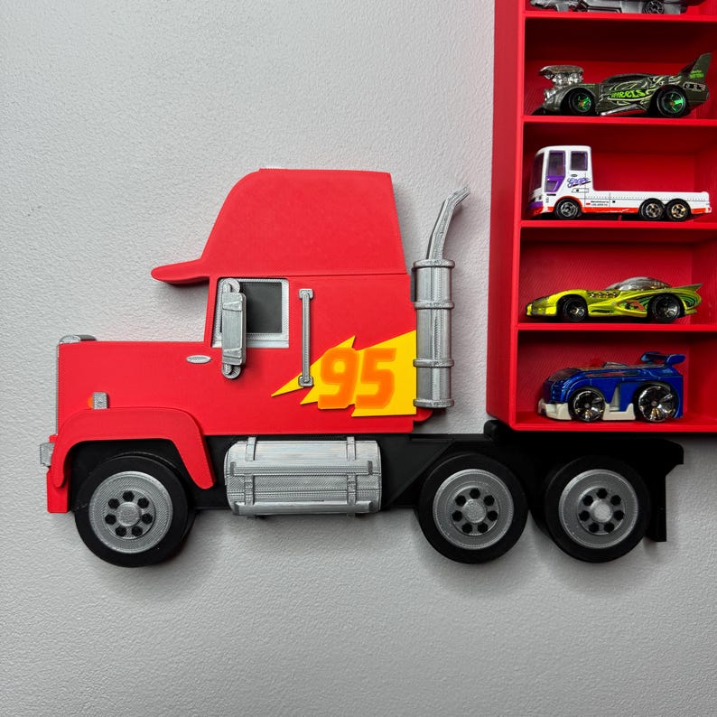 May include: A red semi-truck-shaped shelf with the number 95 and a lightning bolt graphic. The shelf has a red interior with multiple shelves holding toy cars. The truck has silver accents and black wheels.
