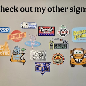 K&ouml;nnte beinhalten: Eine Sammlung farbenfroher, gestanzter Schilder mit verschiedenen Designs und Texten. Schilder sind "Mood Springs", "Motor Oil", "Cozy Cone Motel", "Ding Park", "Heavy Metal Mater" und "Air Mater". Das Bild enth&auml;lt auch den Text "Check out my other signs!"