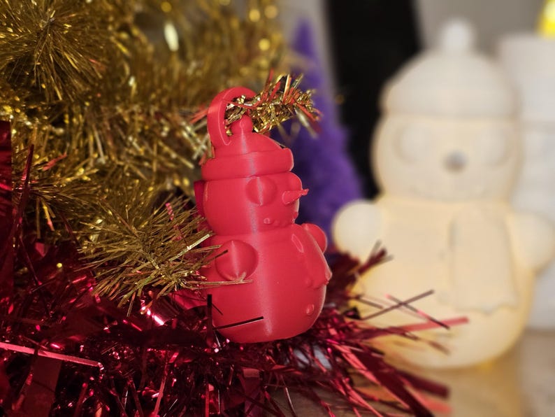 3D-printed snowman ornament made from PLA, available in vibrant colours with a built-in loop for hanging. Perfect for decorating Christmas trees, wreaths, or as festive gifts. Lightweight and durable, adding a handmade charm to holiday décor.