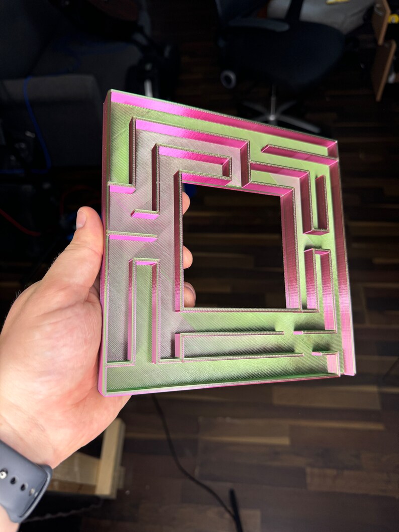 A 3D-printed, decorative light switch cover with a maze-like design. The intricate pattern adds a unique and playful touch to any room, making it both functional and visually appealing for various settings.