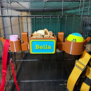 Dog crate organiser in wood effect with a custom nameplate. Stores poo bags, treats, tennis balls, and leads. Perfect for keeping dog accessories organised on walks or car trips. Ideal for dog walkers and owners seeking convenience and style.