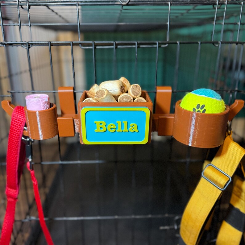 Dog crate organiser in wood effect with a custom nameplate. Stores poo bags, treats, tennis balls, and leads. Perfect for keeping dog accessories organised on walks or car trips. Ideal for dog walkers and owners seeking convenience and style.
