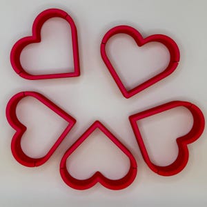 Set of five red heart-shaped place card holders, perfect for weddings, bridal showers, and romantic events. Durable and stylish, these holders add charm to reception tables and complement any wedding theme. Ideal for displaying name cards elegantly.