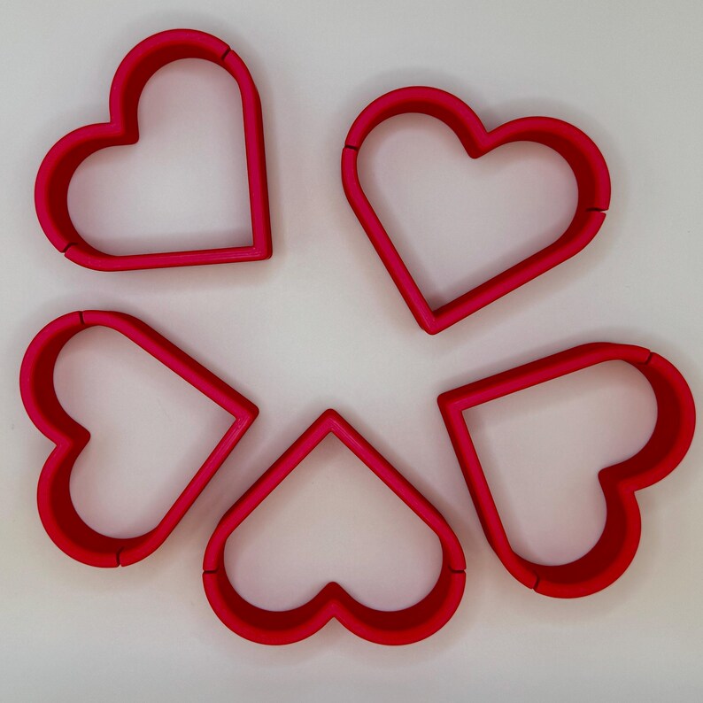 Set of five red heart-shaped place card holders, perfect for weddings, bridal showers, and romantic events. Durable and stylish, these holders add charm to reception tables and complement any wedding theme. Ideal for displaying name cards elegantly.