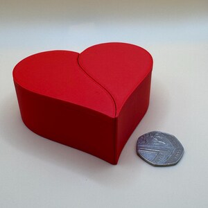 A compact 3D-printed heart-shaped box in vibrant red, shown next to a 50p coin for scale. Ideal for jewellery, small keepsakes, or Valentine’s Day gifts, this split design box is crafted from durable eco-friendly PLA with a smooth and sleek finish.