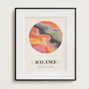 May include: A framed print with a colorful abstract design in shades of pink, orange, yellow, green, and black. The print features the word "BALANCE" in bold black letters and a quote: "Balance is not something you find, it's something you create." - Jane Fonda.