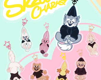 May include: A set of eight colorful cartoon animal charms with black eyes and black clothing. The charms are attached to keychains with star-shaped tops. The charms are labeled "SKZOO CHARMS!"