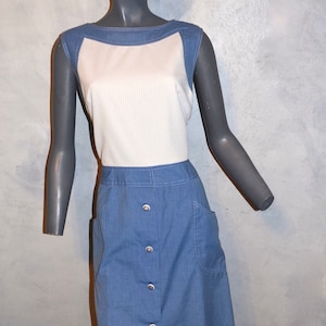 May include: A blue and white sleeveless dress with a button-up front and pockets. The dress has a white striped bodice and a solid blue denim skirt.