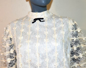 1960s 70s Long lace tunic style blouse with puffed sleeves.  Black velvet bow.  By Alex Coleman.  VFG Ivory Cream. Bow accents.
