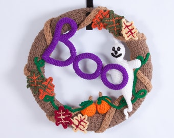 May include: A brown crocheted wreath with purple crocheted letters spelling "BOO" and a white crocheted ghost with a smiling face. The wreath is decorated with green vines, orange and brown crocheted leaves, and orange crocheted pumpkins.
