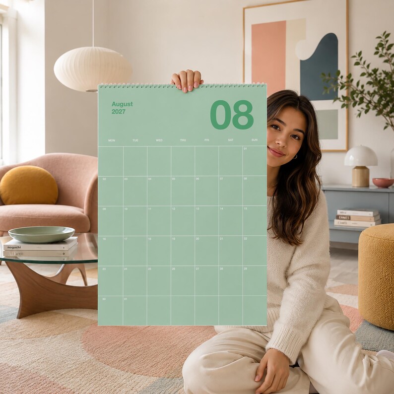 Op de afbeelding: Een wandkalender voor augustus 2027 met een saliegroene achtergrond, witte rasterlijnen en witte tekst. De kalender toont de maand en het jaar in de linkerbovenhoek en het getal 08 in een groot lettertype in de rechterbovenhoek.