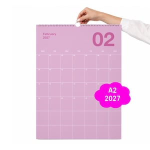 Op de afbeelding: Een wandkalender voor februari 2027 met een lichtpaarse achtergrond en witte rasterlijnen. De kalender bevat de tekst February 2027, het getal 02 en een roze wolkachtige afbeelding met de witte tekst A2 2027.