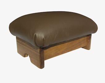 May include: A brown leather footstool with a wooden base. The footstool has a rounded top and a simple design.