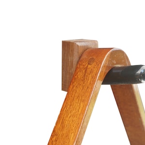 Könnte beinhalten: Ein dreieckiger Holzständer für Billardkugeln mit einer schwarzen Gummikappe oben. Der Ständer ist aus dunklem Holz mit polierter Oberfläche.