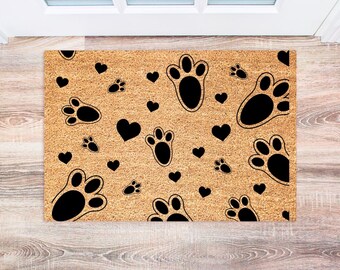 May include: A brown coir doormat with a black paw print and heart pattern.